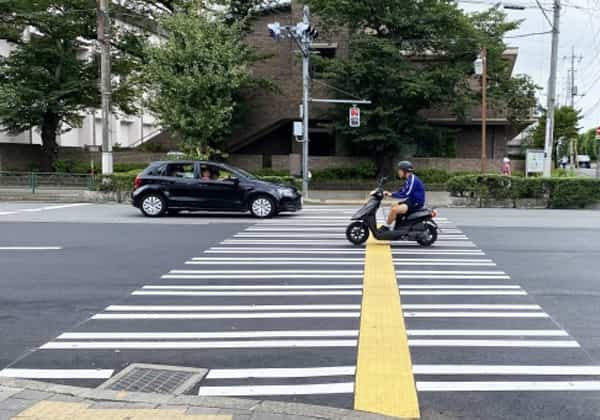 交差点で車とバイクが移動している写真