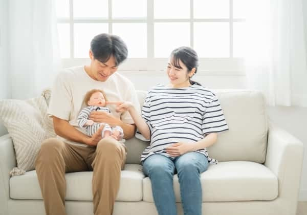 親子が赤ちゃんを抱いている画像